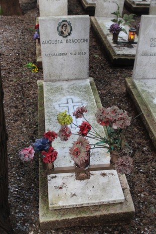 Tombe con fiori e candele commemorative, dedicate ai caduti per la Libertà in un cimitero.