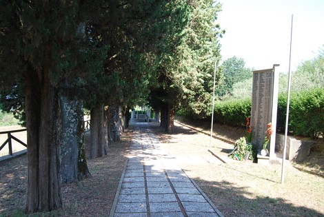 Monumento dedicato alle vittime della strage di Valla, immerso in un viale di cipressi, simbolo di memoria e riflessione.