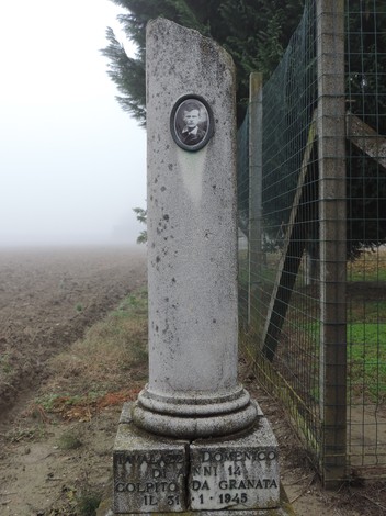 Cippo commemorativo in memoria di Domenico, colpito da granata nel 1945, immerso nella nebbia.
