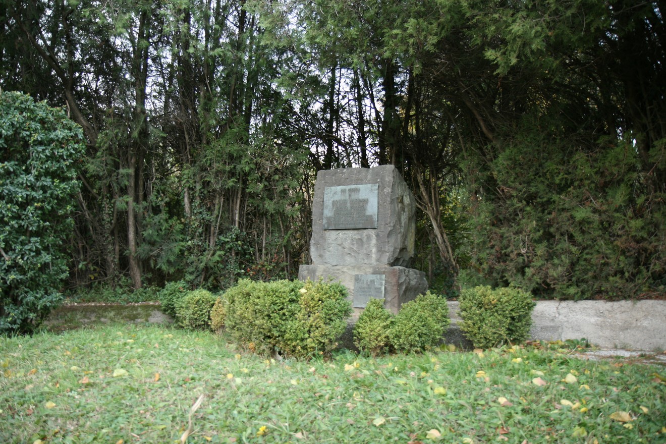 Monumento ad Amendola, situato in un'area verde, circondato da alberi e cespugli.