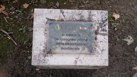 Cippo commemorativo dedicato ai colognesi vittime delle deportazioni nazifasciste, con simboli e scritte.
