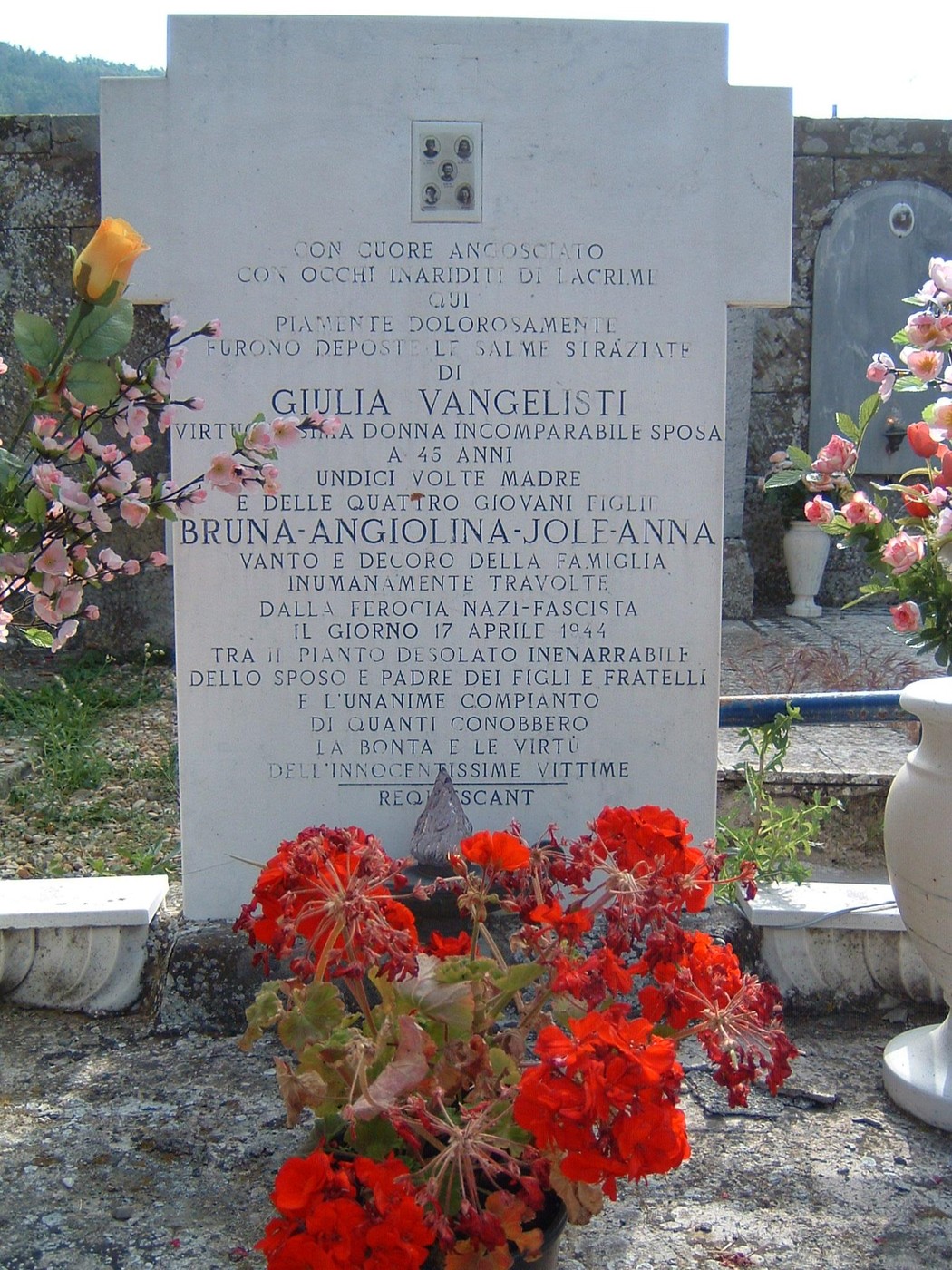 Tomba delle donne di Berceto, commemorazione con fiori e iscrizioni, simbolo di ricordi affettuosi e di vite.