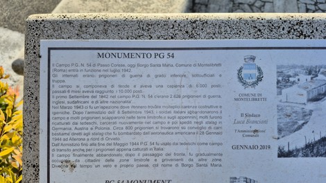 Monumento al Campo PG54, commemorazione storica con dettagli architettonici e ambientazione naturale.