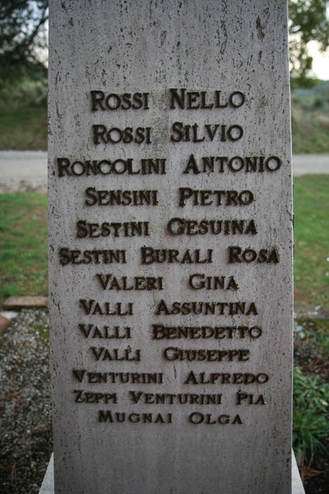 Cippo commemorativo dell'eccidio di Cornia con i nomi delle vittime incisi. Monumento di memoria storica.