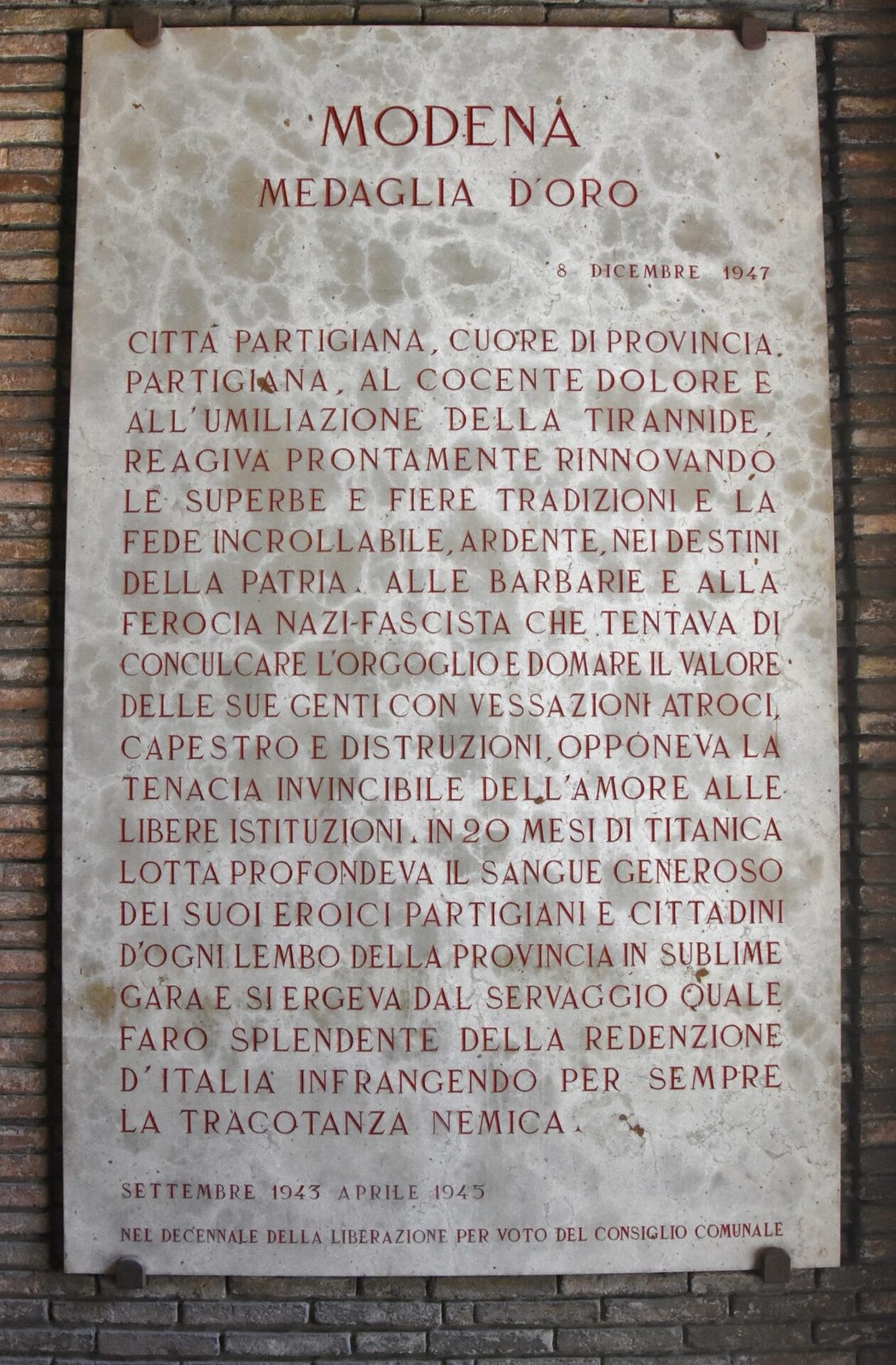 Lapide commemorativa che celebra la Medaglia d’Oro al Valore Militare per atti di eroismo.