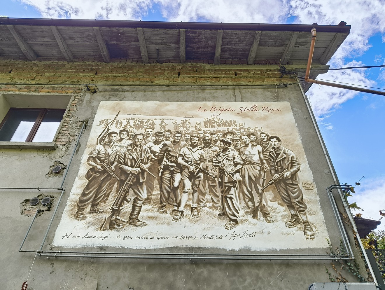 Murale commemorativo della Brigata Stella Rossa, ritraente soldati in posa e simboli di resistenza.