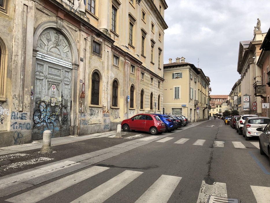 Pietra d'inciampo dedicata a Olivelli su una strada di una città italiana, con edifici storici sullo sfondo.