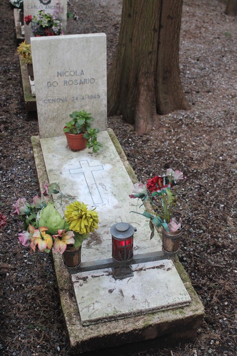 Tombe con fiori e candele, commemorano i caduti per la Libertà in un ambiente sereno.