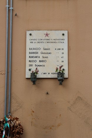 Lapide commemorativa ai caduti per la Libertà di Ponte Carrega, con nomi e fiori commemorativi.