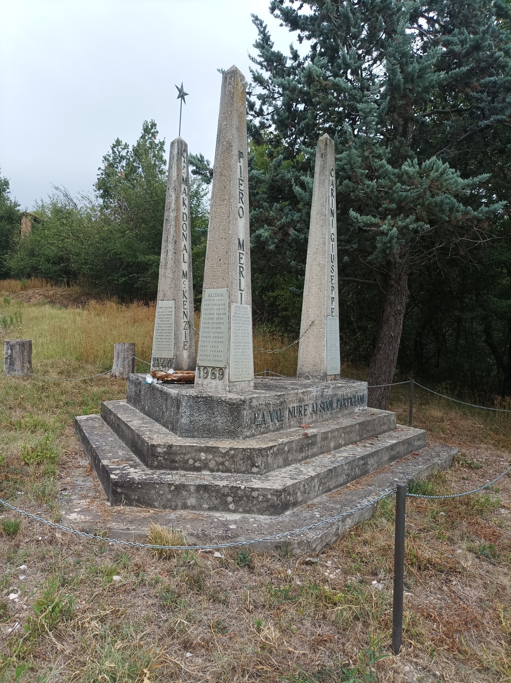 Monumento ai partigiani della Valnure, con obelischi e iscrizioni commemorative in un'area verde.