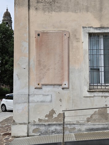 Lapide commemorativa dedicata ai caduti della guerra 1940-1945, affissa a una parete esterna.