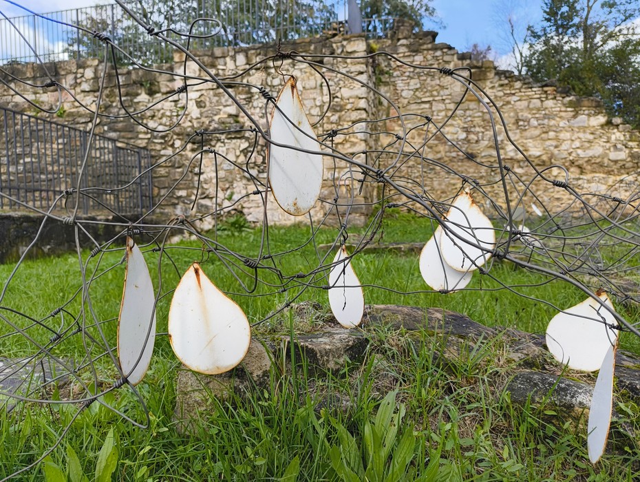 Rovine di San Martino immerse nel verde, con elementi artistici in contrasto con la storia e la natura circostante.