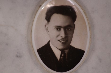 Ritratto di un giovane uomo in abito formale, conservato in un'incorniciatura ovale su marmo.