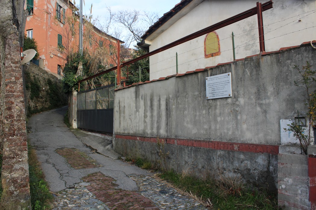 Lapide commemorativa alla famiglia Pirc, posta su un muro in un tranquillo contesto urbano.