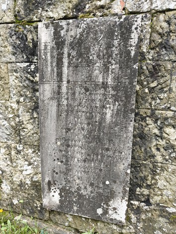 Sepolcri delle vittime di Giuncheto, memoriale in pietra su muro antico. Atmosfera di commemorazione e rispetto.