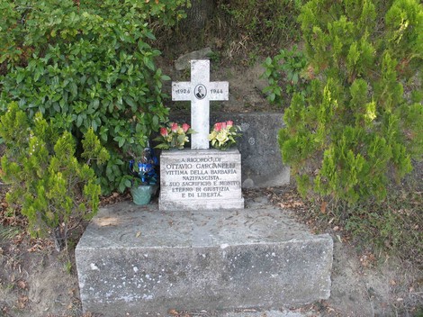 Monumento a Garganelli, commemorazione con croce e fiori in un ambiente naturale.