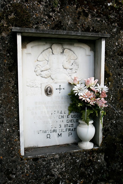 Targa commemorativa nel Parco della memoria di Terrinca, con decorazioni floreali e simboli di commemorazione.